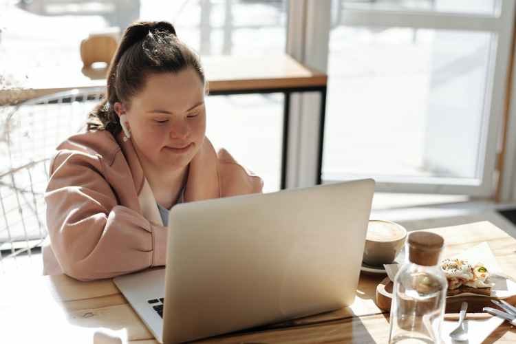 Young woman using a laptop while having breakfast.